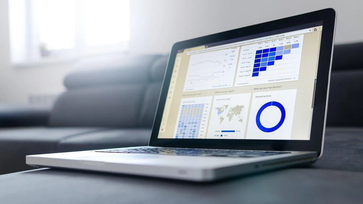 Laptop on a desk showing an analytics dashboard with charts and a world map