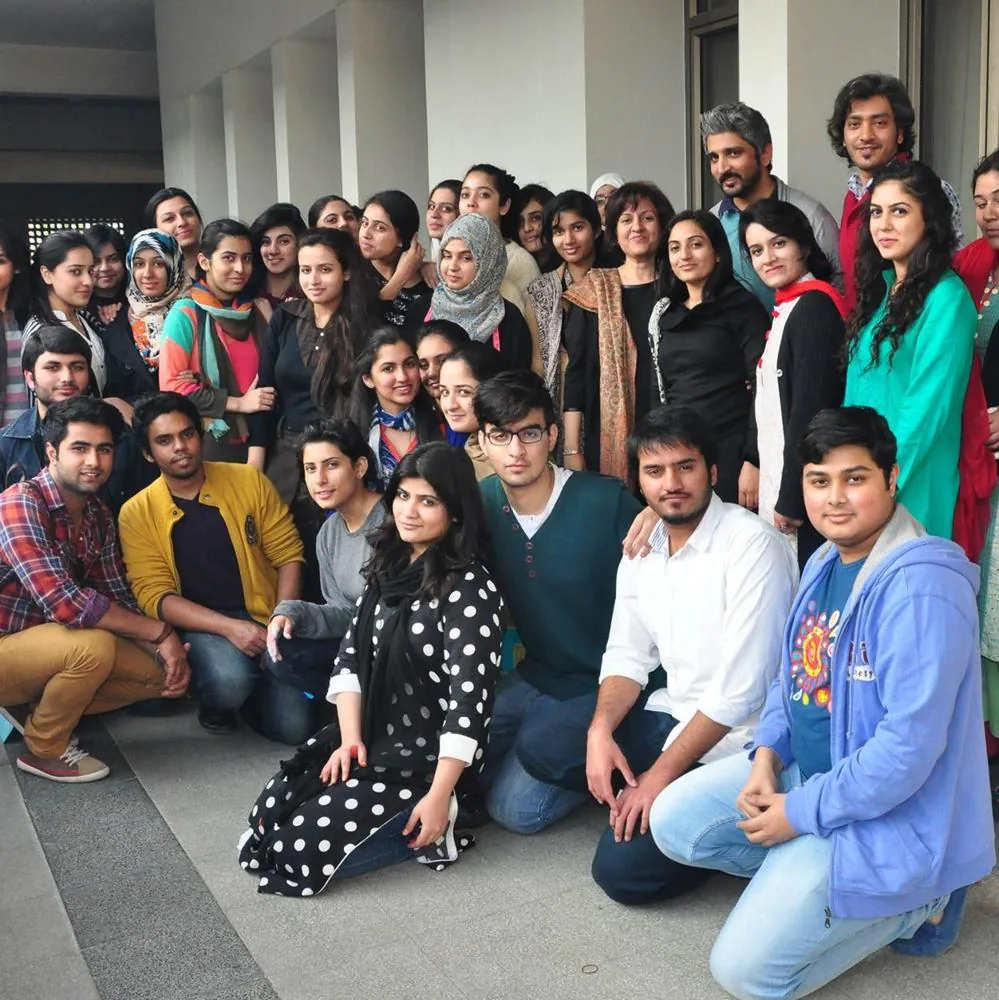 Large group of students and instructors posing together outside a building