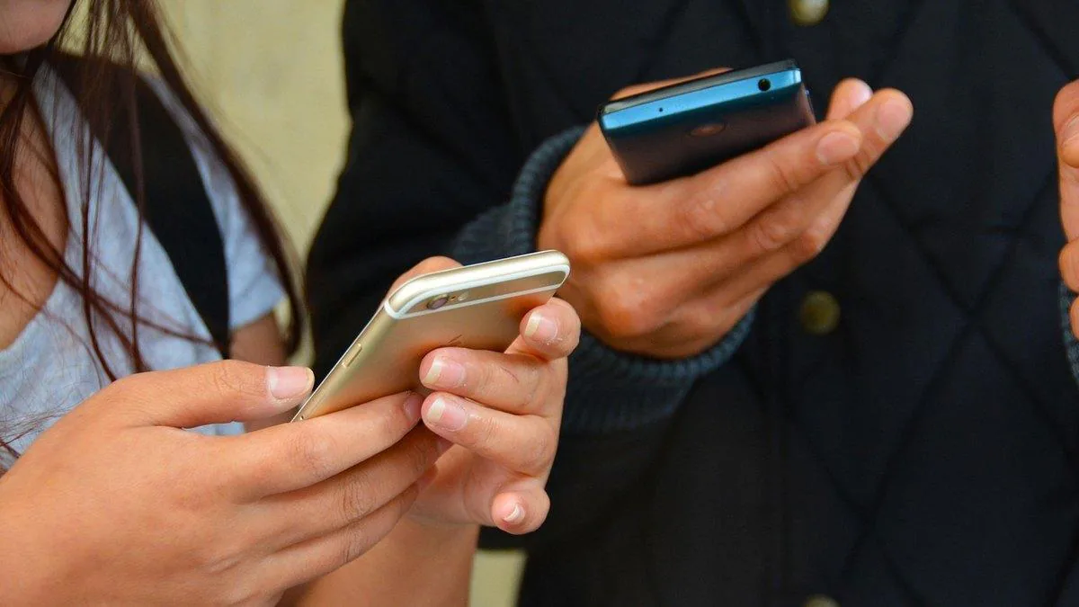 Two people's hands holding smartphones, typing and scrolling