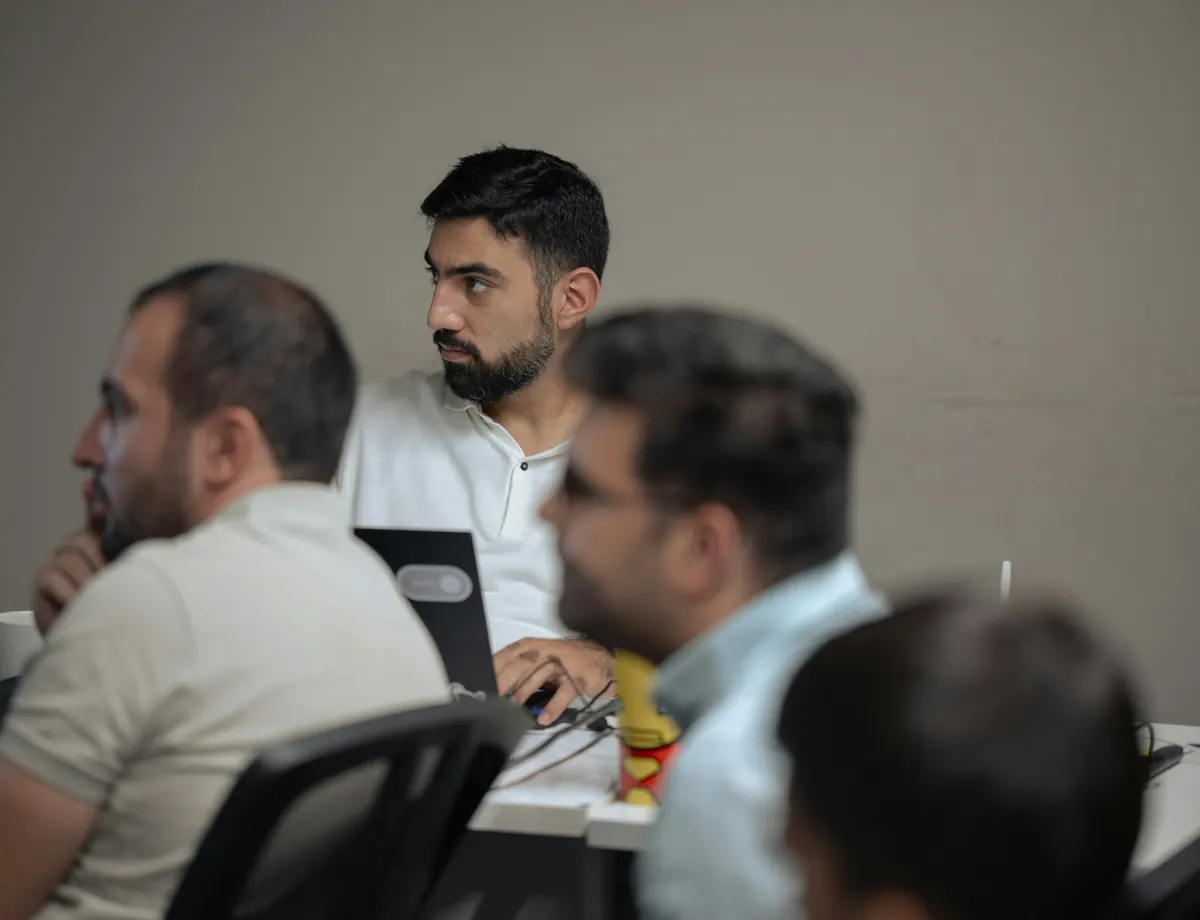 Consultants listening intently during a working session around laptops