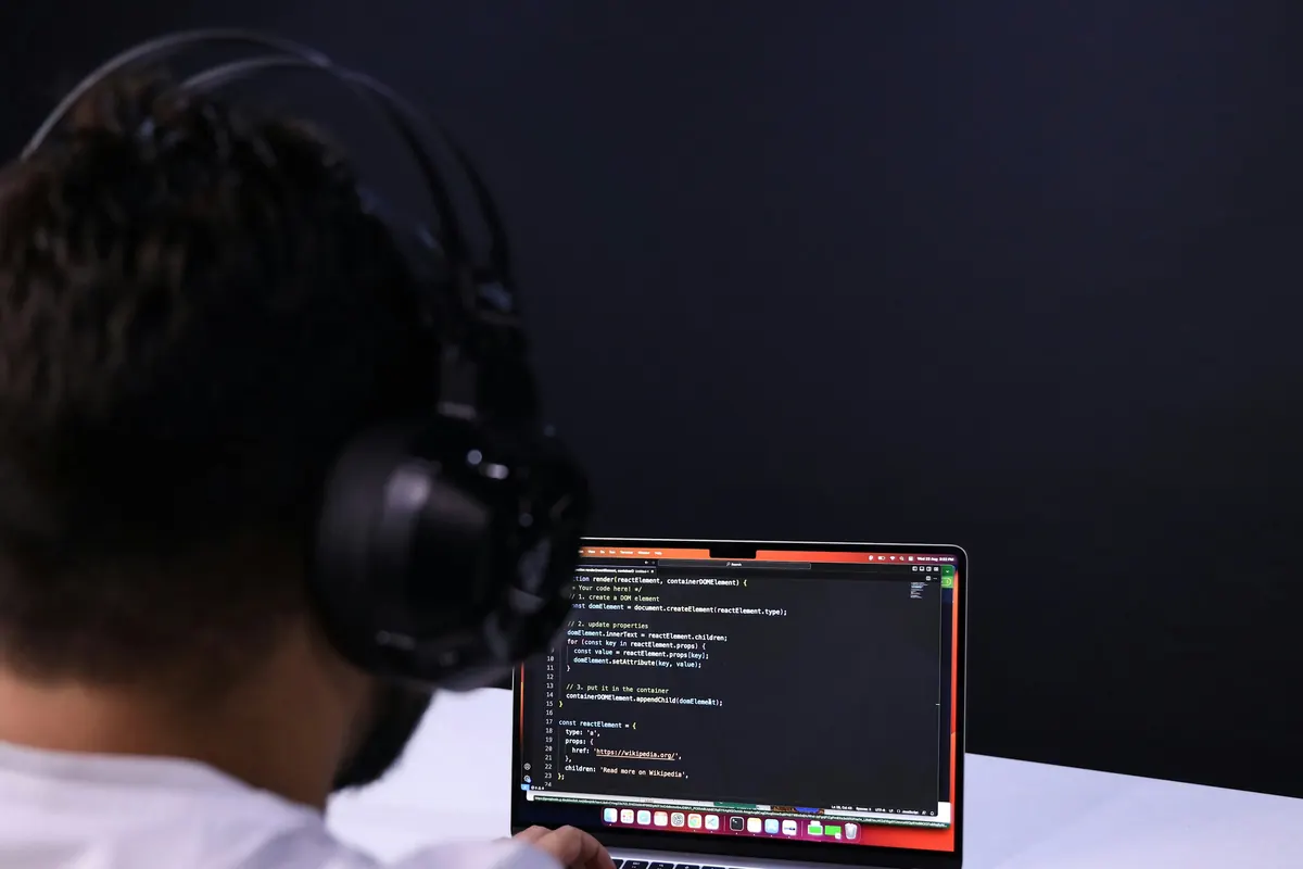 Developer wearing headphones writing code on a laptop in Jaipur