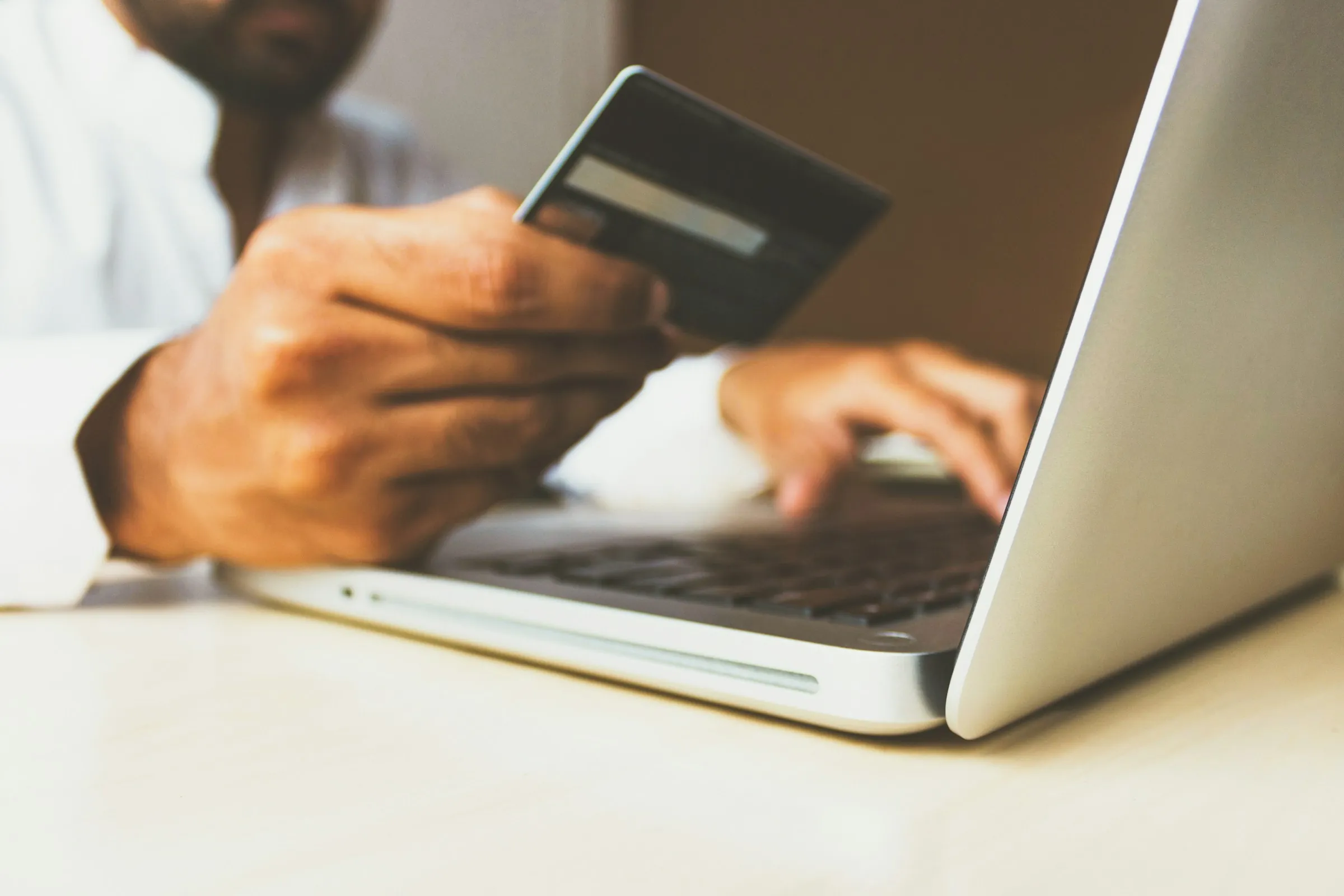 A shopper paying by card while checking out online on a laptop
