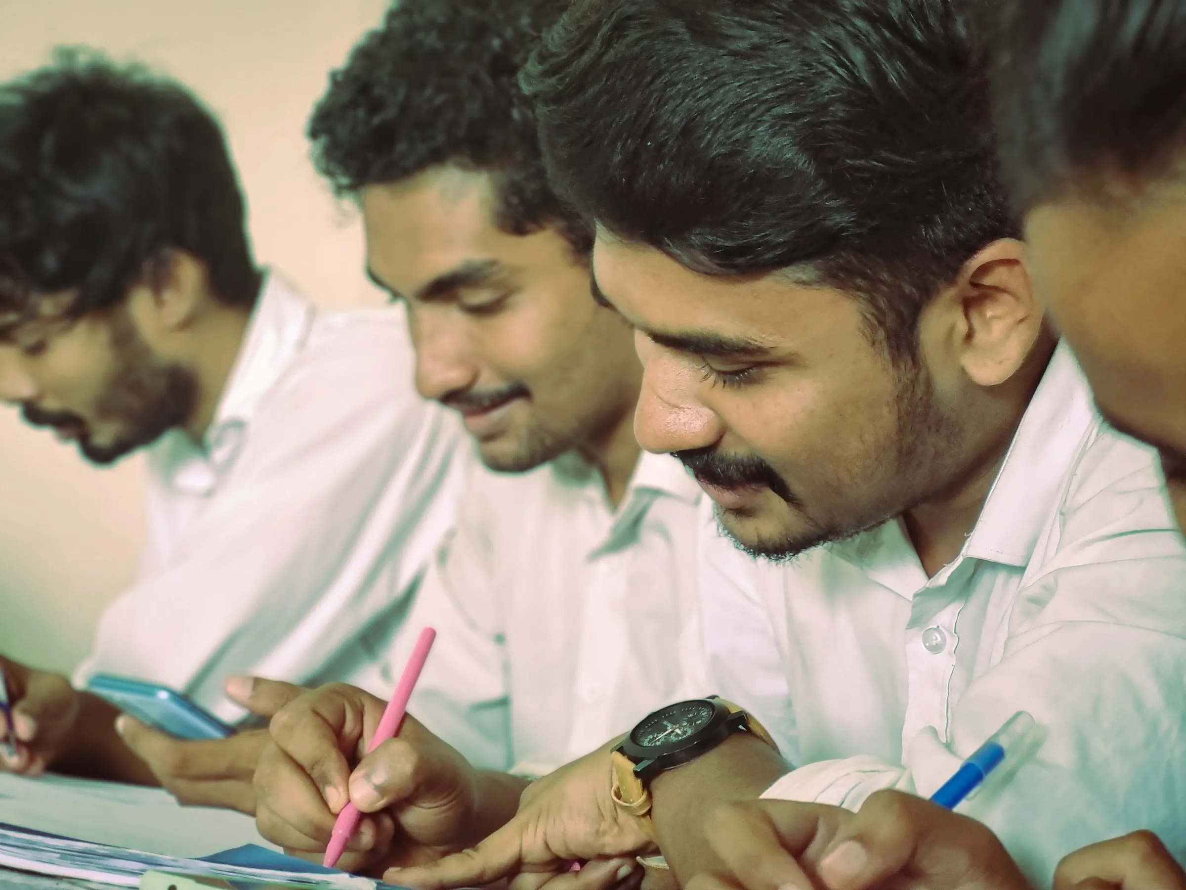 Young trainees in white shirts writing notes during a session in Kerala