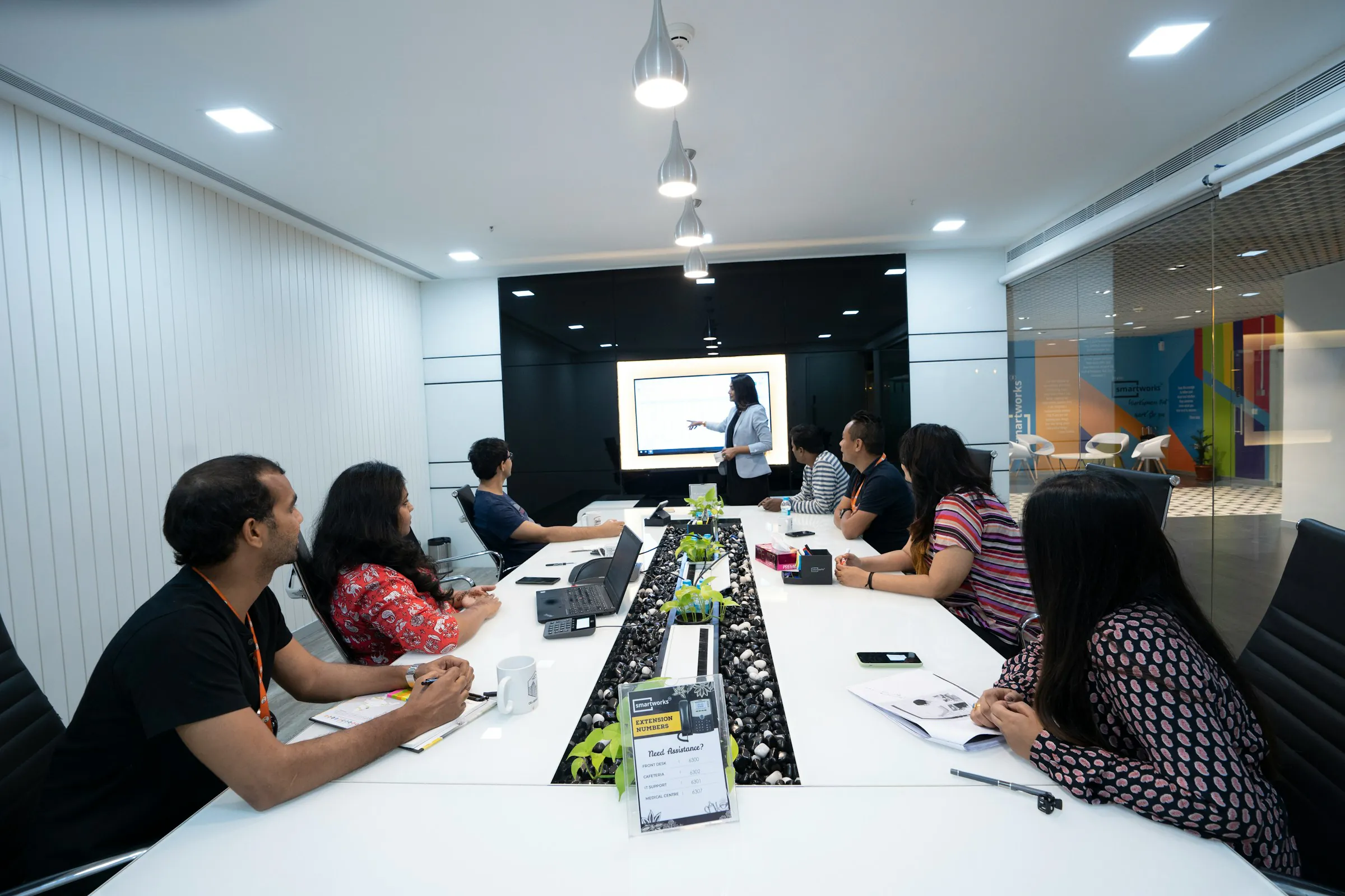 A trainer leading an AI product management session for professionals working on laptops